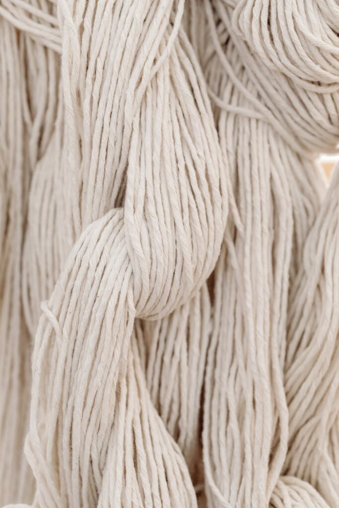 High-quality close-up of white cotton yarn, showcasing intricate weaving details.